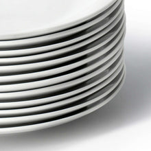 Stacked white porcelain dinner plates with smooth rims, close-up view.