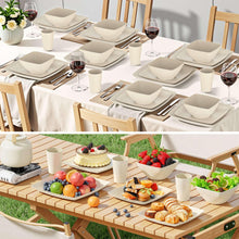 Beige square dinnerware set laid out on a table with plates, bowls, and cups