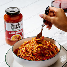 Jar of Smash Kitchen Organic Classic Marinara beside a bowl of sauced spaghetti