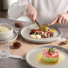 Speckled ceramic dinnerware set with shallow plates and bowls