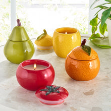 Yellow ceramic lemon fruit candle with lit wick and matching lid on tabletop