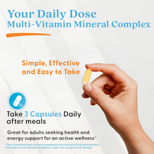 Hand holding a yellow veggie capsule, daily dose multi-vitamin mineral complex