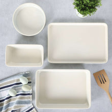 White 4-piece metal bakeware set with round dish, large rectangular tray, and two square dishes