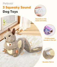 Grey plush squirrel dog toy on floor, long tail and orange fabric tag