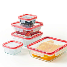 Glass food storage containers with red lids, holding assorted meal prep portions