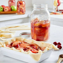 Glass mason jar with metal lid, filled with red preserved food