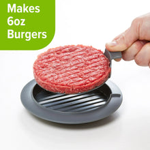 Burger press pushing a raw burger patty onto a ridged cooking plate