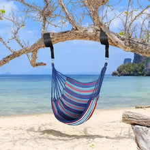 Striped canvas hammock chair swing hanging from a tree with black support straps