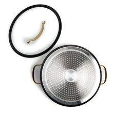 Black non-stick stock pot with gold-tone handles and perforated bottom and lid