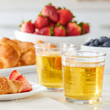 Apple juice glasses with fresh fruit on a tray, two clear tumblers