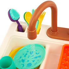 Plastic sink basin with brown faucet, scrub brush, teal dish, and colored cups