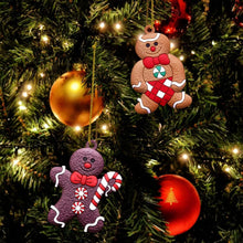Gingerbread man ornaments with candy-cane details hanging on a Christmas tree