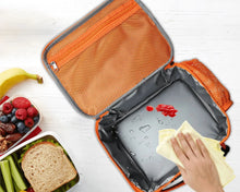 Orange insulated lunch bag open with gray lining; snack items and hands nearby