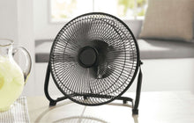 Metal high-velocity fan on stand with wire grille and black blades, front view