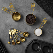 Stainless steel measuring spoon set with five gold spoons, flat lay