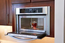 Clear glass mug on the turntable inside a microwave oven