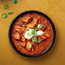 Tikka masala in a bowl with creamy sauce, chicken pieces, and cilantro