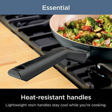 Black non-stick pan with heat-resistant handle on gas stovetop
