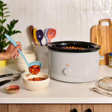 bella slow cooker on countertop with glass lid and temperature knob