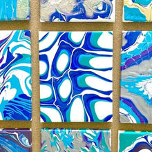 Set of small stretched canvases with blue abstract marbling paint on display