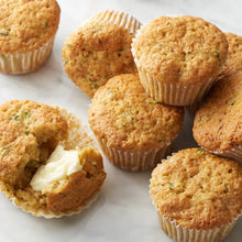 Butter with canola oil spread on cornbread muffins on a white plate