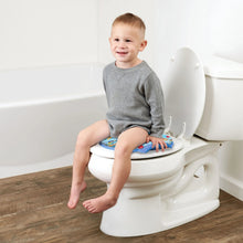 Toddler sitting on a toilet with a Bluey potty training seat