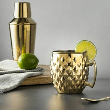 Gold stainless steel Moscow mule mug with diamond texture and lime slice garnish