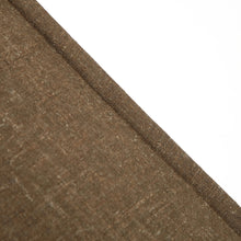 Brown linen fabric edge detail showing textured seam