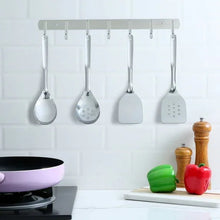 Stainless steel utensils hanging on rack: four spatulas and spoons