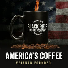 Black Rifle Coffee Company mug with roasted beans and American flag design in background
