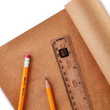 Kraft paper roll sheet with ruler and pencil on brown paper