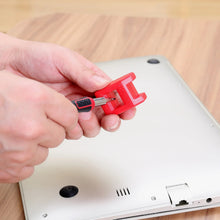 Hand holding red precision screwdriver to insert a bit on a metal electronics panel