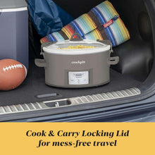 Grey slow cooker with locking lid and control panel placed in vehicle cargo