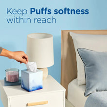 Facial tissue box with tissue pulled up on bedside table, Puffs Ultra Soft