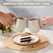 Two cream ceramic coffee mugs with handles, reactive glaze, clinking over cake