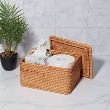 Brown rattan organizer basket with lid open, holding tissue and supplies inside.
