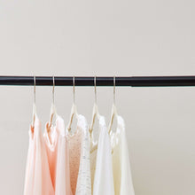 Black closet rod with hangers holding shirts