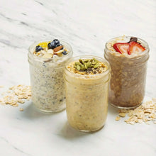 Regular-mouth mason jars with metal lids, filled contents, clear glass
