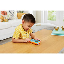 Toddler boy sitting at table playing with VTech Bluey ring phone toy