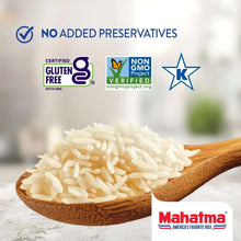 Pile of uncooked jasmine rice on a wooden spoon