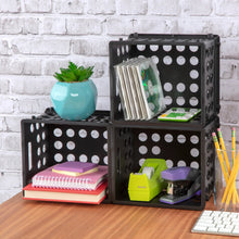 Stacked black plastic storage crates with open fronts and perforated side panels