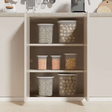 Open pantry organizer cabinet with clear food storage canisters and white lids