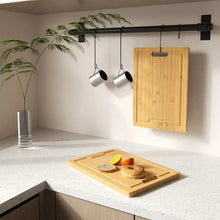 Bamboo cutting board with hanging slot and side handle cutouts, rectangular board.