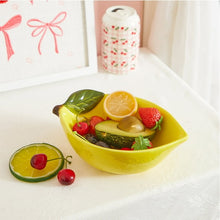 Yellow ceramic lemon bowl holding sliced fruit and berries