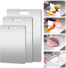 Titanium cutting boards set with handle cutouts, shown while slicing citrus, meat, and veg