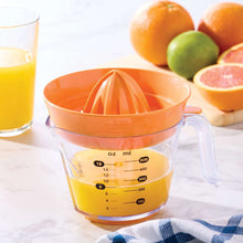 Orange citrus juicer with clear pitcher showing measurement markings and pour spout
