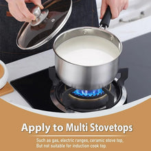 Stainless saucepan on gas burner with black handle, lid held nearby