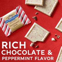 Peppermint bark chocolate squares and broken pieces in paper wrappers
