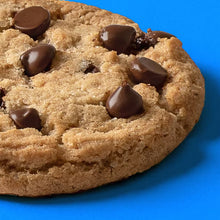 Chocolate chip cookie topped with dark chocolate pieces and golden cookie crumbs