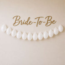 Row of white latex balloons across a wall for a party backdrop